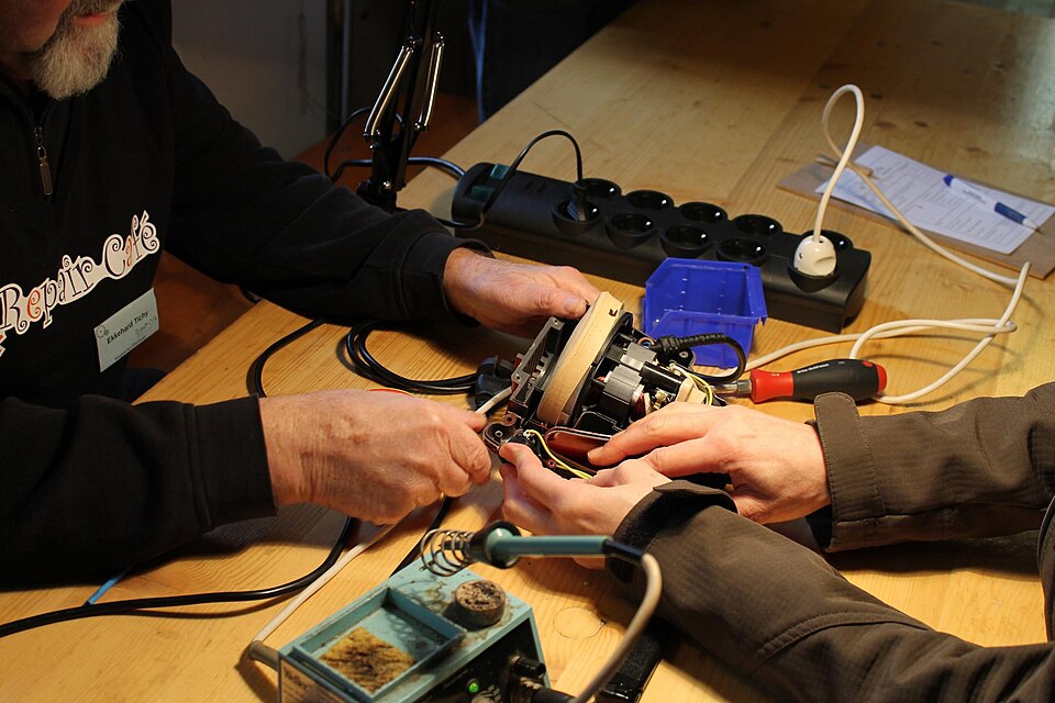 Volunteers repairing a small appliance at a repair café