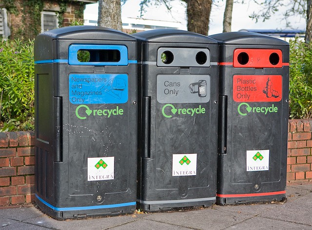 Colour-coded recycling bins outside a shop